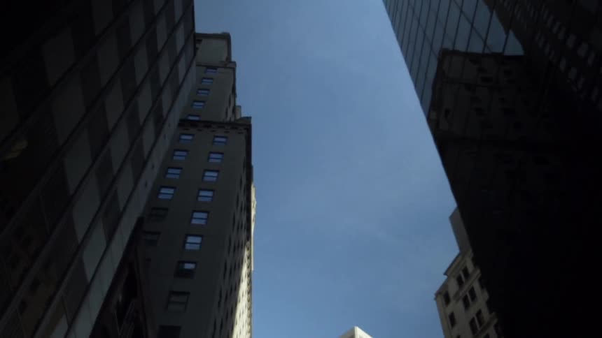 Looking up at tall buildings moving down a street