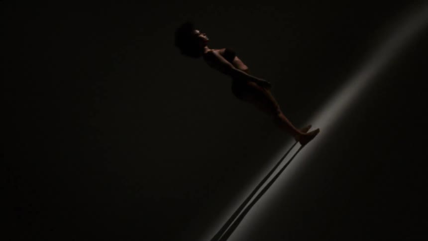 Warping and twisting image of woman standing in empty room casting shadows