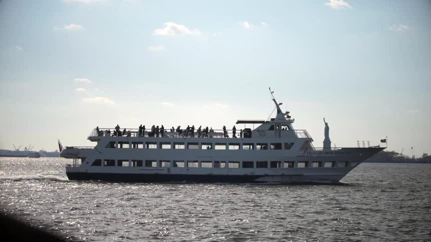 A large yacht carrying people is sailing in the water
