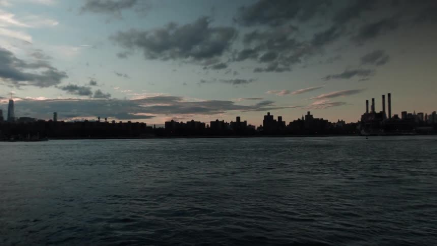 A city sits across the water at sunset
