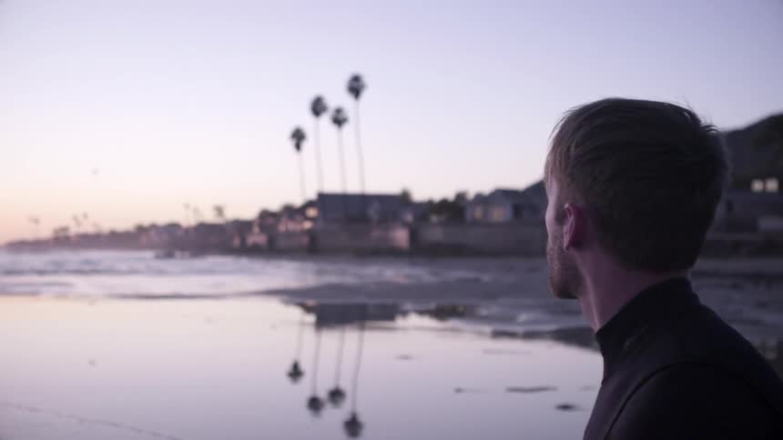 A man in a wet suit looks around