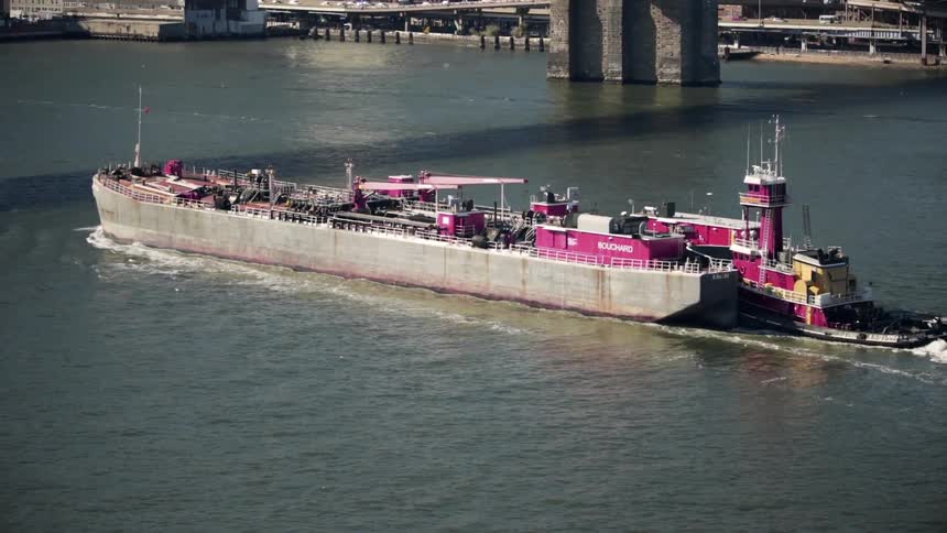 A large freight ship is moving in the water
