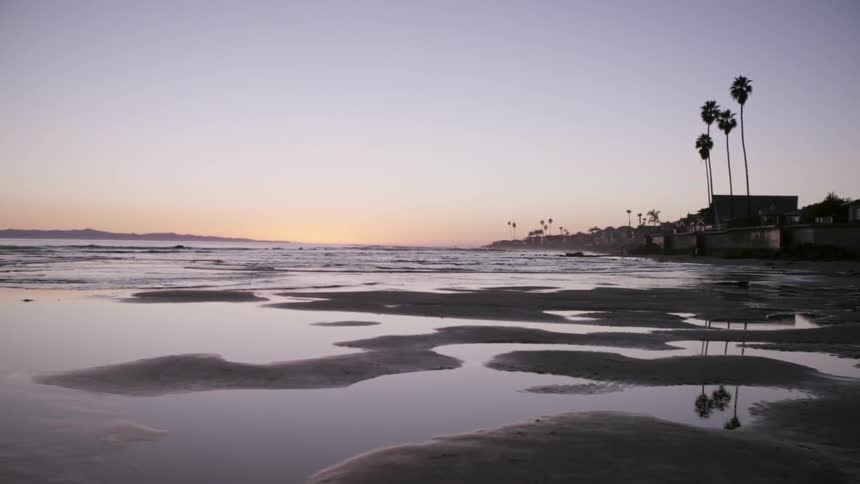 Water is slowly moving on to the shore at sunset
