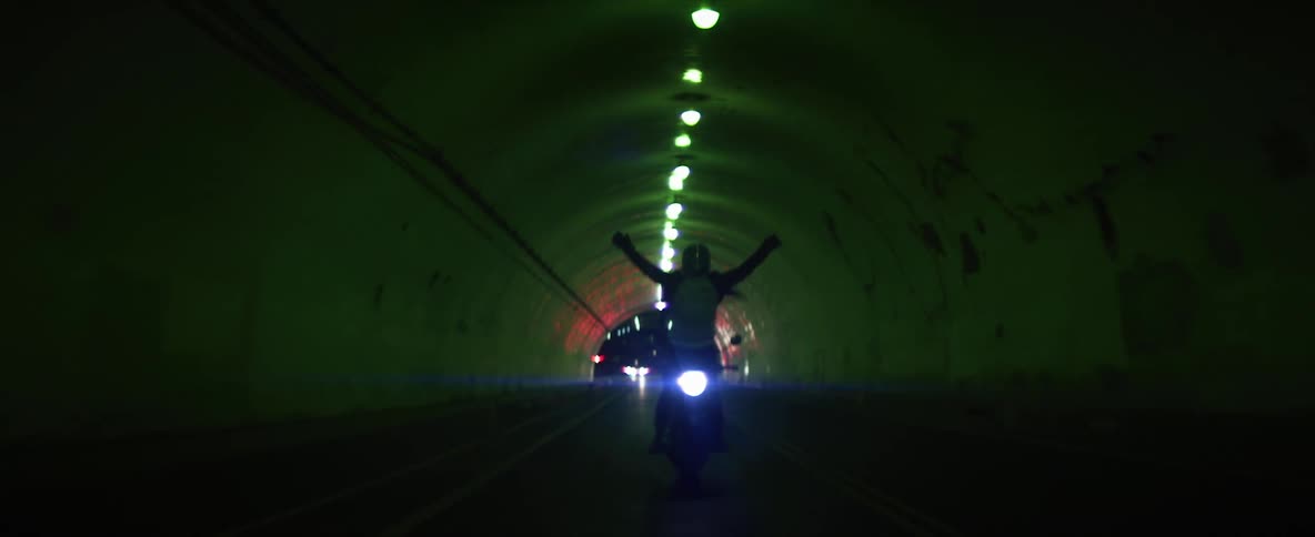Biker rides motorcycle through tunnel at night