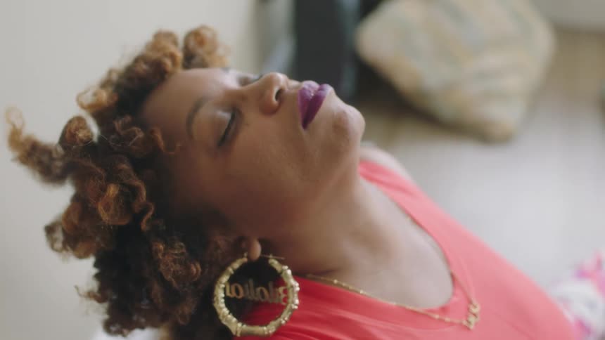 Mature woman sitting on the floor at home with her head tilted up relaxing