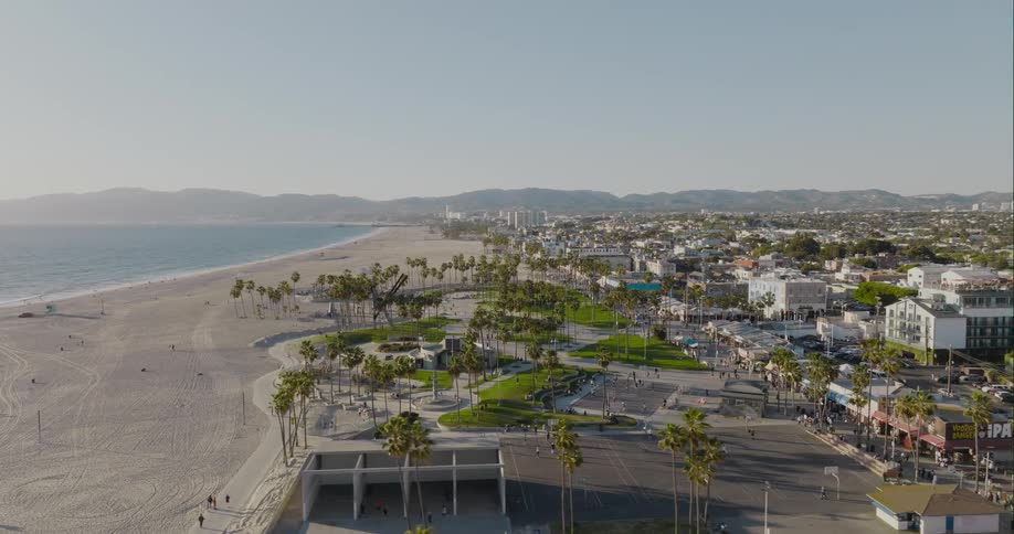 Aerial view of a group of people using the sports courts on a park near the beach at morning