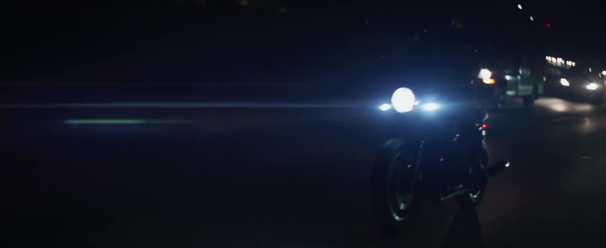 Biker rides motorcyle on highway at night