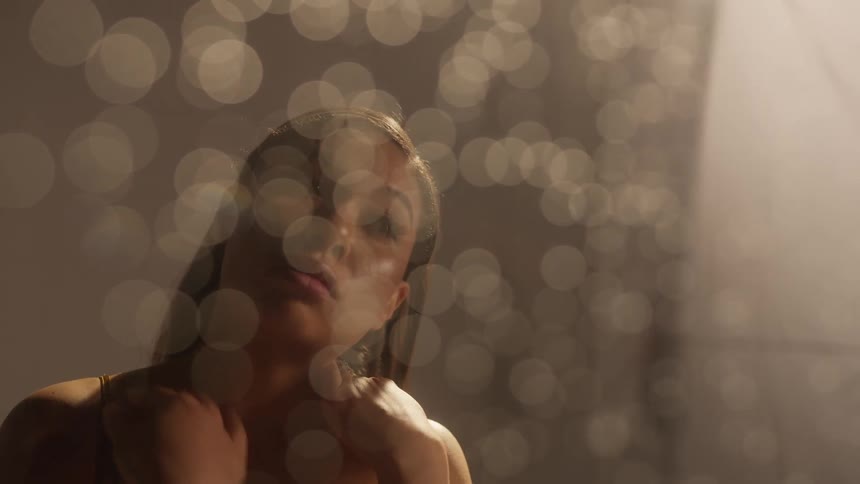 A woman rubs her neck and looks deep in thought