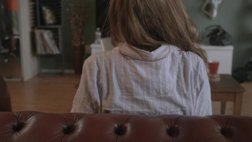 Woman walks over to a couch with a laptop