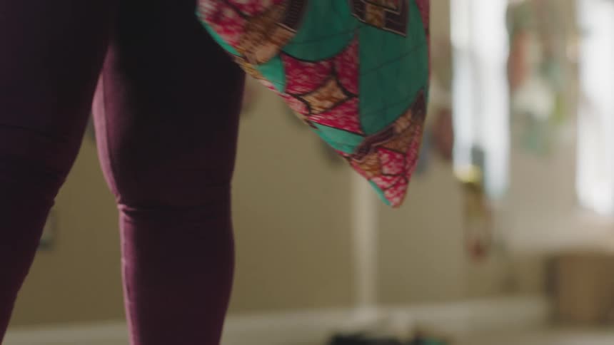 A woman unrolls a yoga mat on the floor and places a cushion on top of it