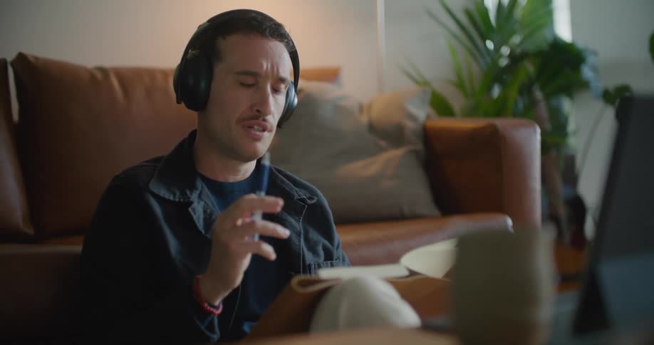 A man sitting in a room looking at a book
