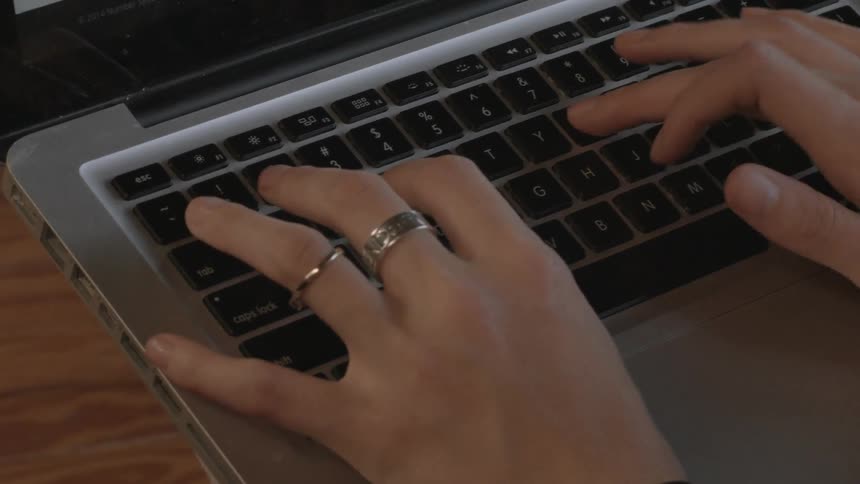A close up of a woman typing on a laptop