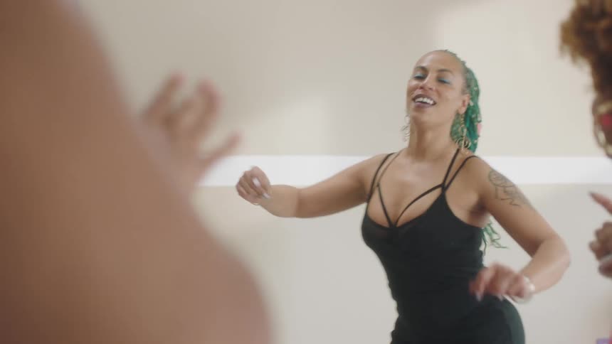 Women stand in rough circle dancing together