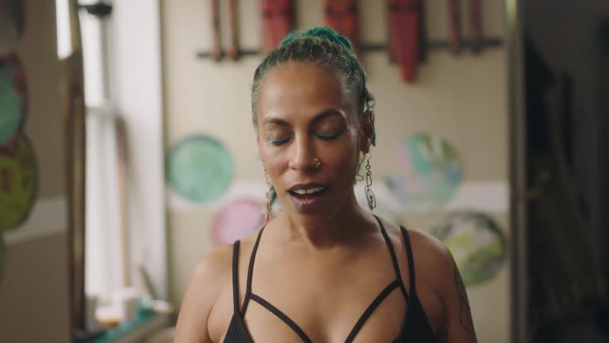 Woman wearing sports clothes takes a deep breath while looking at the camera