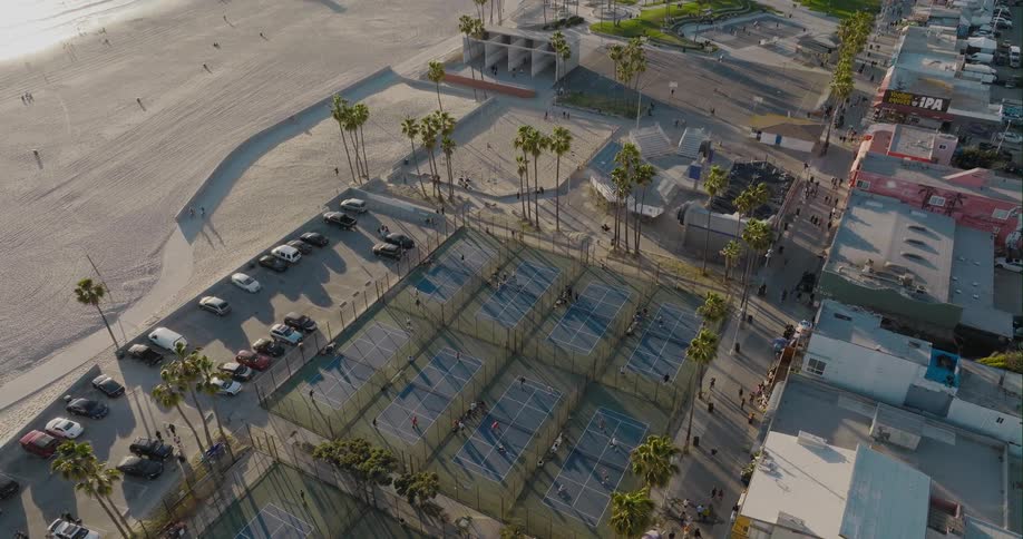 A group of tennis courts in a public park on a beach during the day
