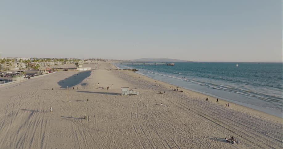 Aerial view of people on the white sand beach next to the ocean