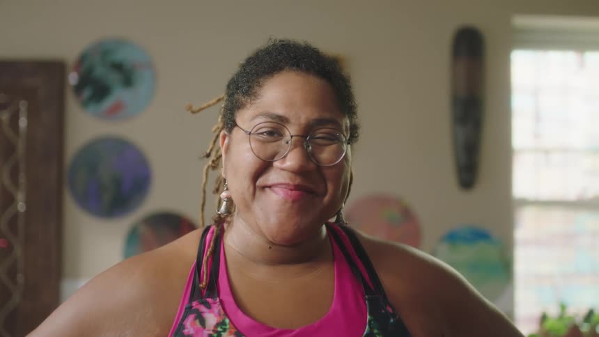 Close up of a woman standing in a room looking at the camera smiling