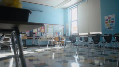 Desks and chairs sitting in a classroom