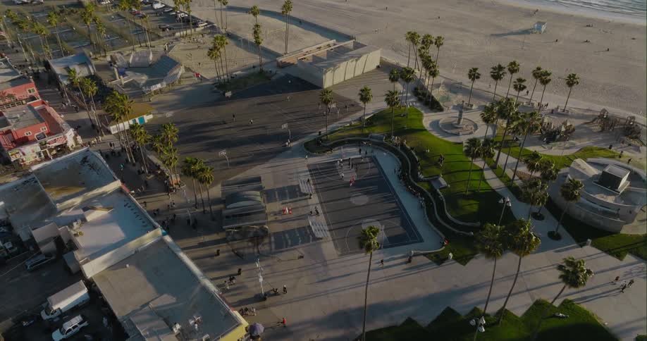 People move along park set between apartment buildings and beach