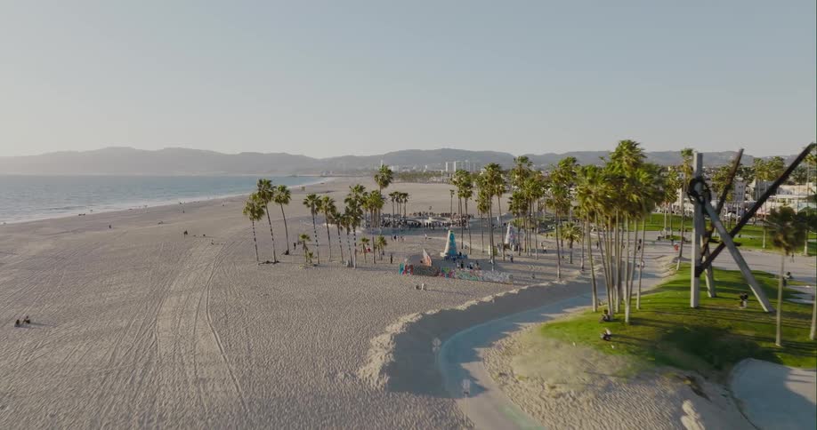 People skateboarding in a skateboard park on the beach near the ocean