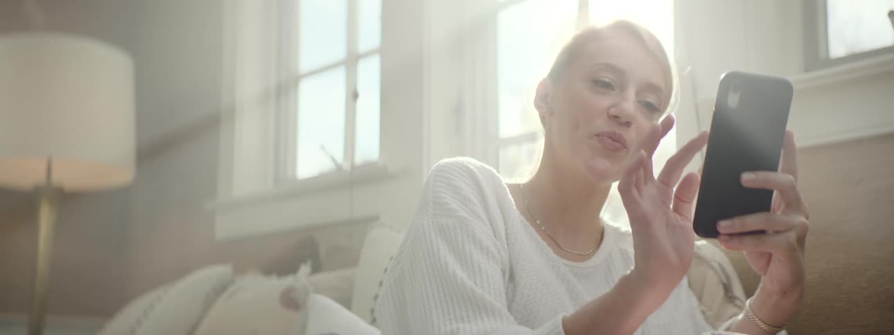 A woman interacts virtually with someone using an app on her cell phone