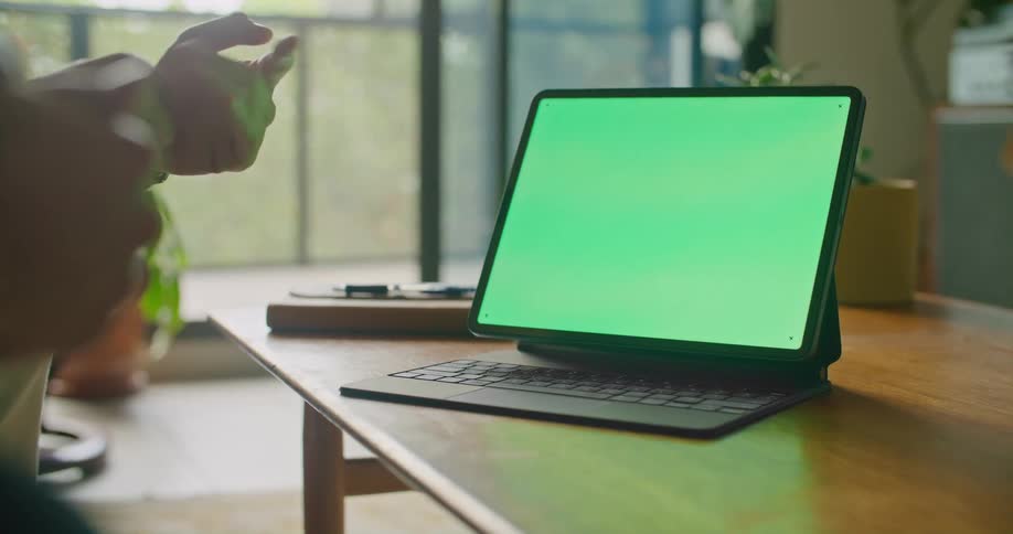 Two people sitting on a couch in front of a tablet with a green replaceable screen