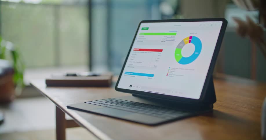A laptop on a wooden table showing a pizza graph and some stats