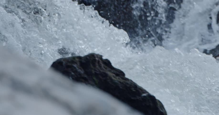 Waterfalls are splashing and foaming as the water hits the rocks and rolls over them