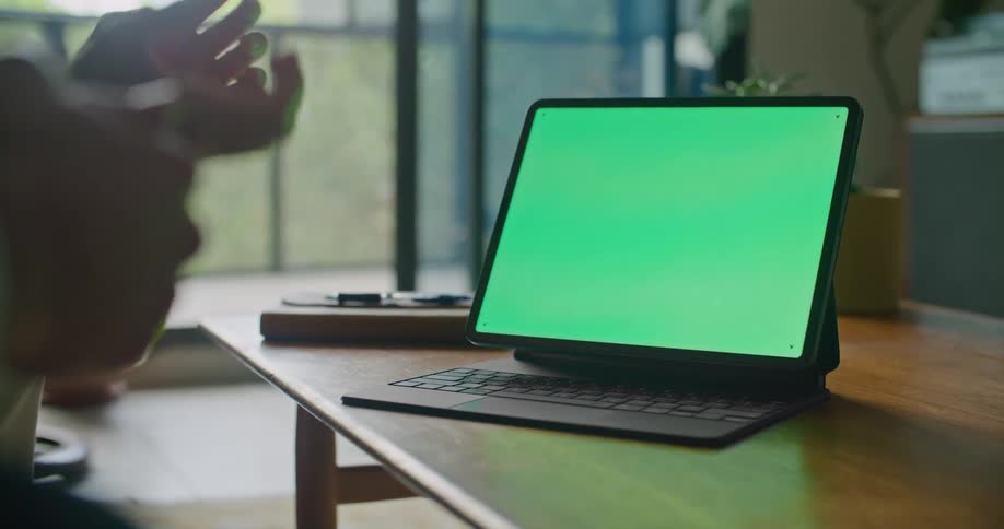 Two peoples hands are visible as they are in front of at a green computer screen