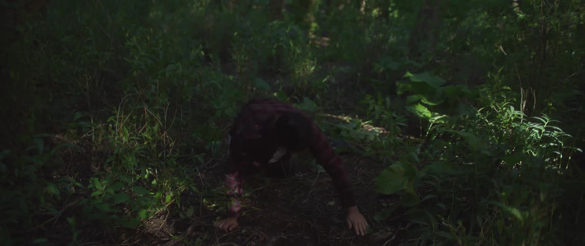Man lying on the forest ground with his face in a puddle of water suddenly getting up very confused and walking away