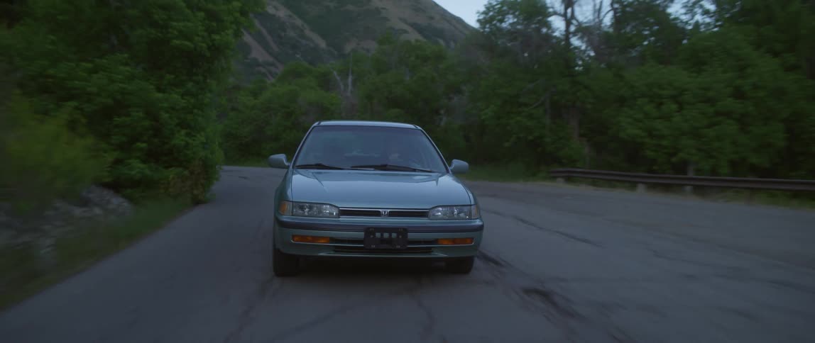 An automobile is traveling around a bend on a mountain road