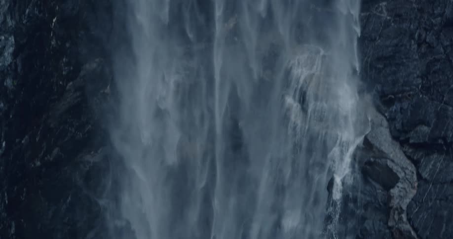 An enormously tall waterfall plummets down the side of a sheer cliff