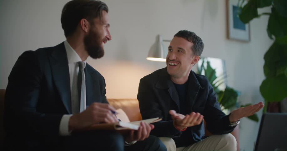 Two men having a business meeting in the living room talking on a video call on a tablet