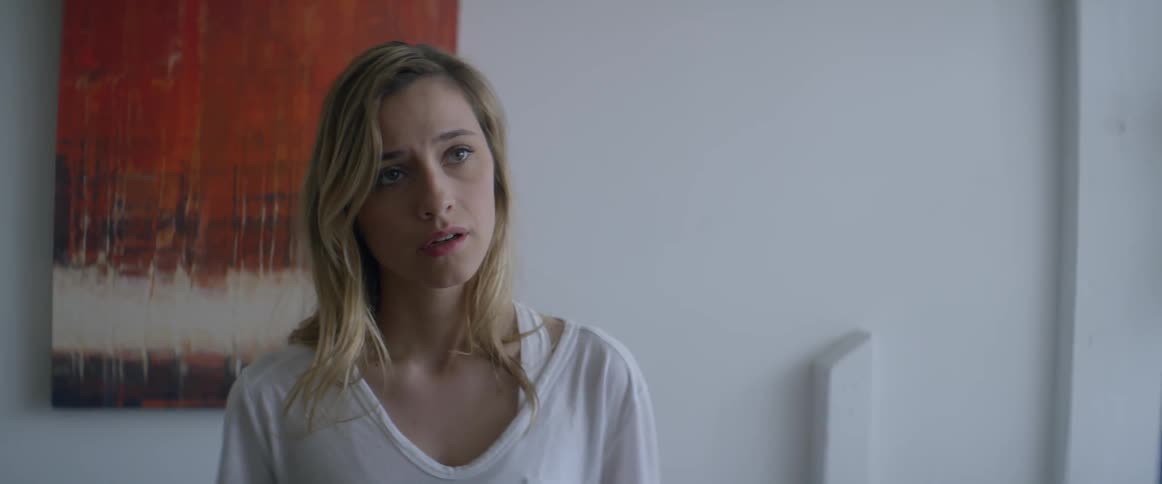 A blonde woman turns her head slightly looking at something