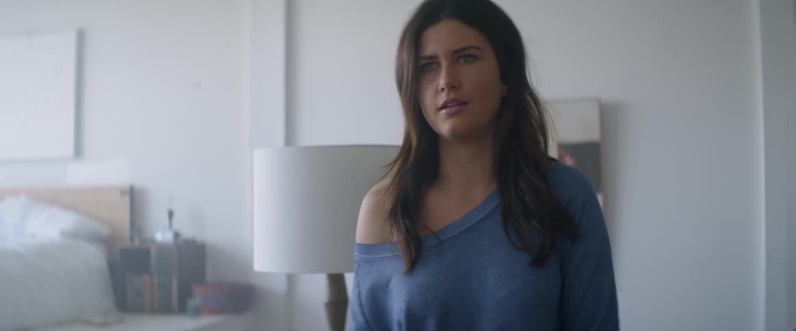 A woman in a blue sweater is talking