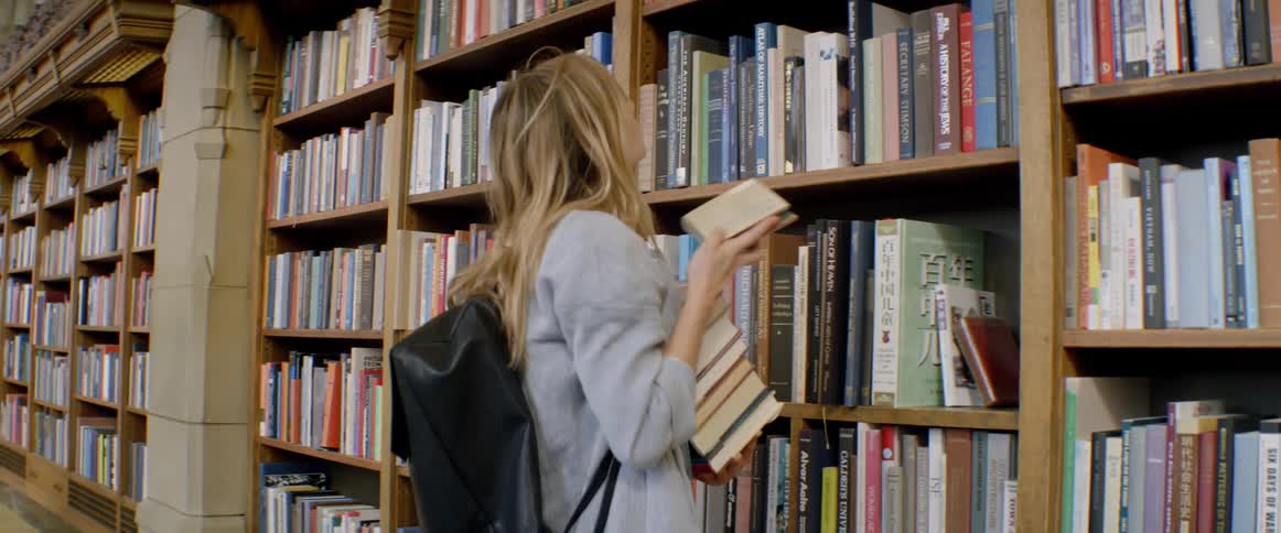 A woman picks up books at the library