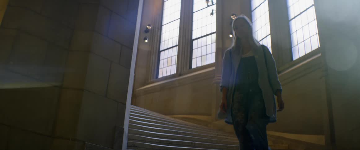 A blond woman walks down the stairs