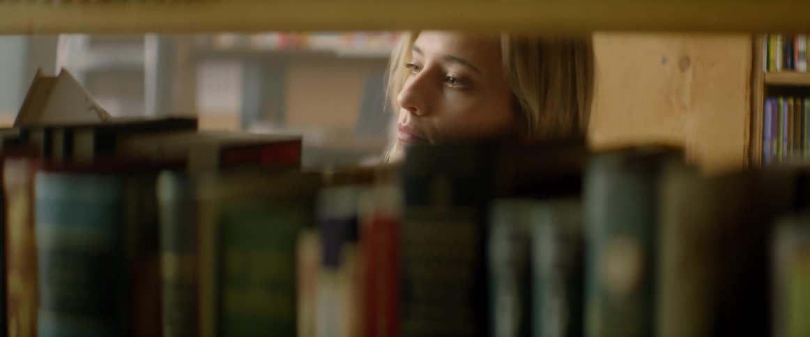 A woman is browsing books in a library