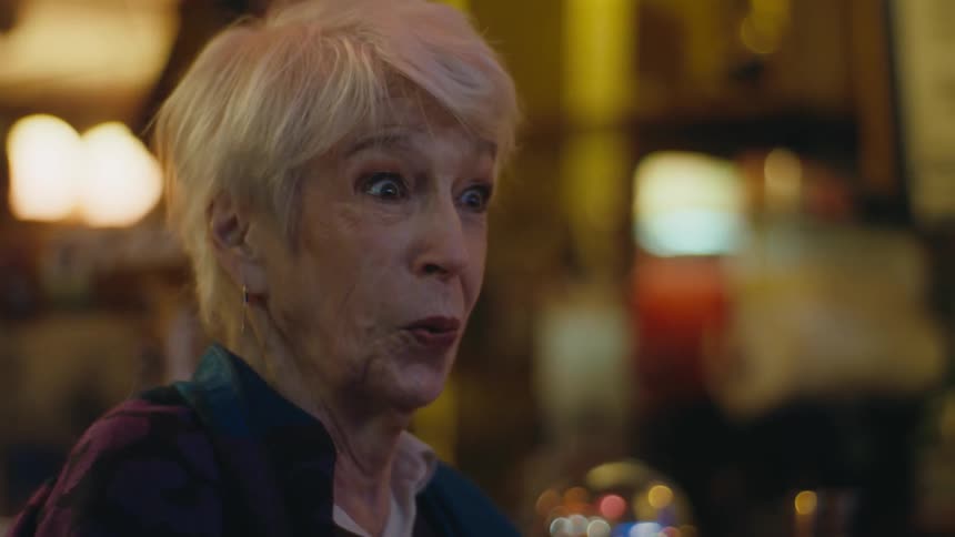 Elderly woman reacts with surprise after drinking a shot of strong liquor at a bar