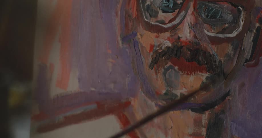 An artist paints a portrait of a man
