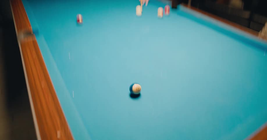 A man hits a pocket while playing pool