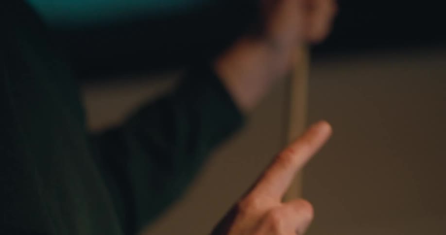 Man with moustache wearing a bandana holding a pool cue talking with hand signs