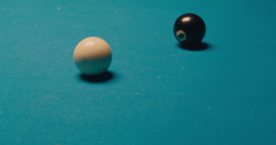 A cue hitting a ball on a pool table