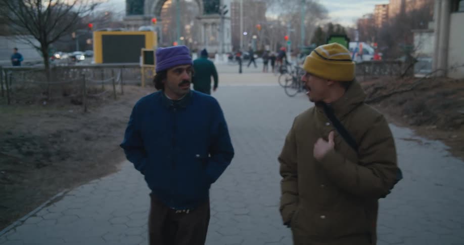 Two friends are walking in a city at dusk