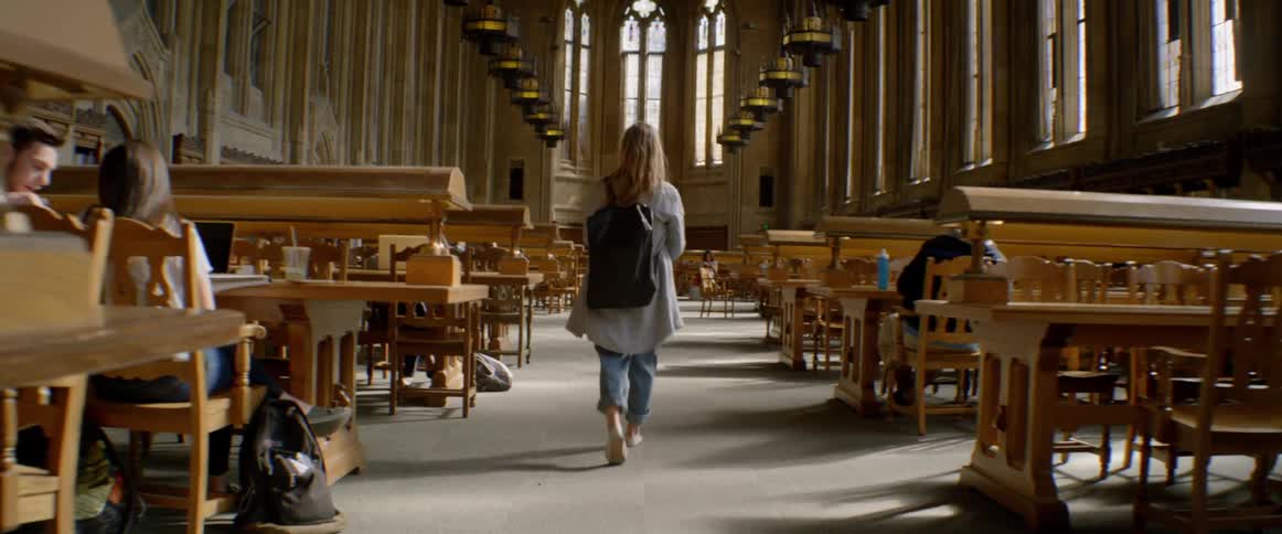 A blonde woman walks out of a library