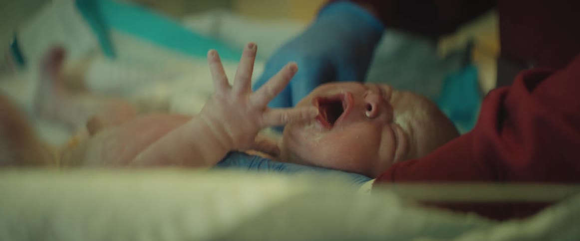 A newborn cries as he is cleaned