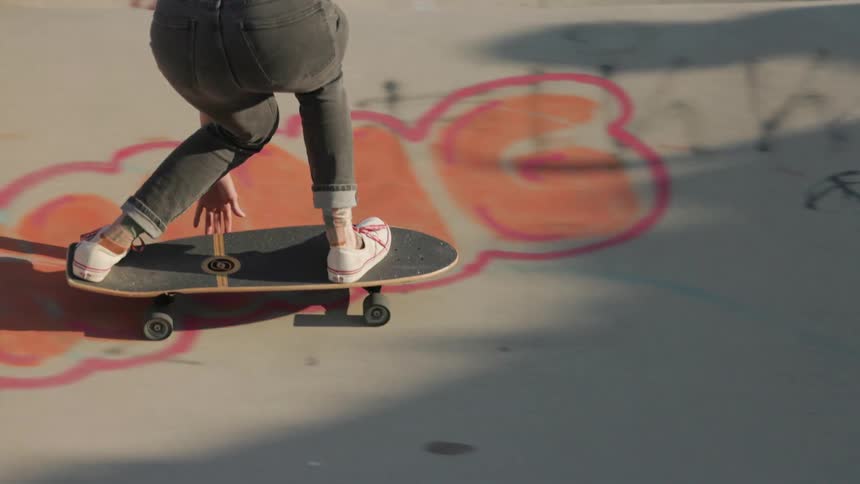 A girl is riding a skateboard in a skateboard park