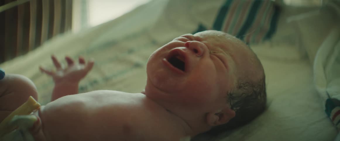 A newly born infant crying while being examined in the hospital
