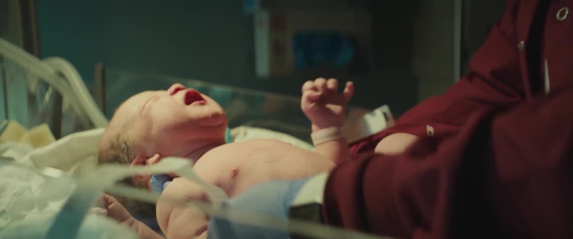 A nurse uses a measuring tape on a newborn in the hospital