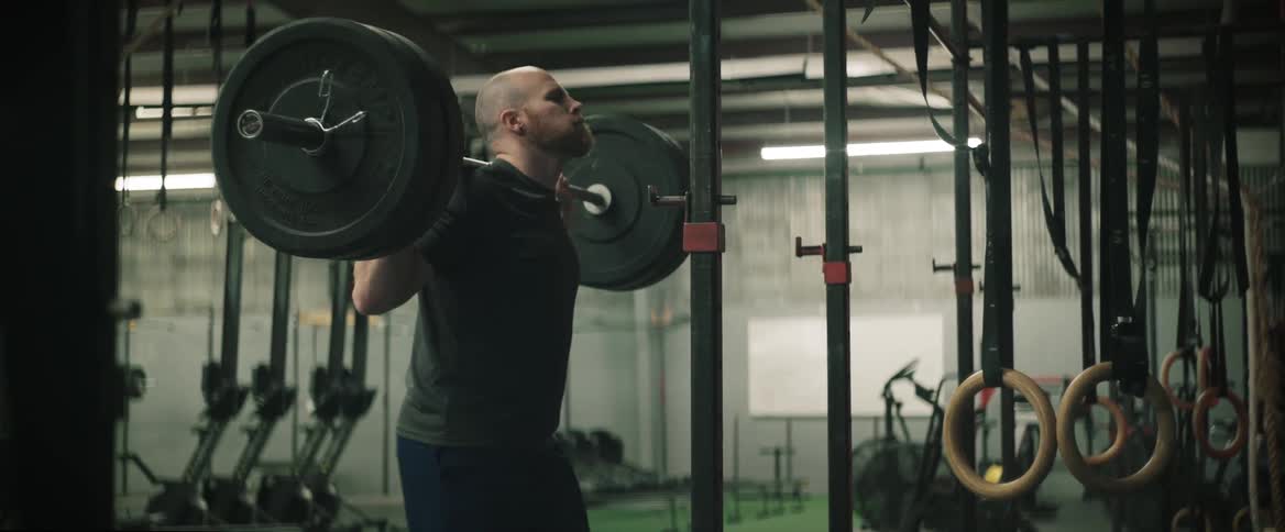 A man is lifting heavy weights in the gym